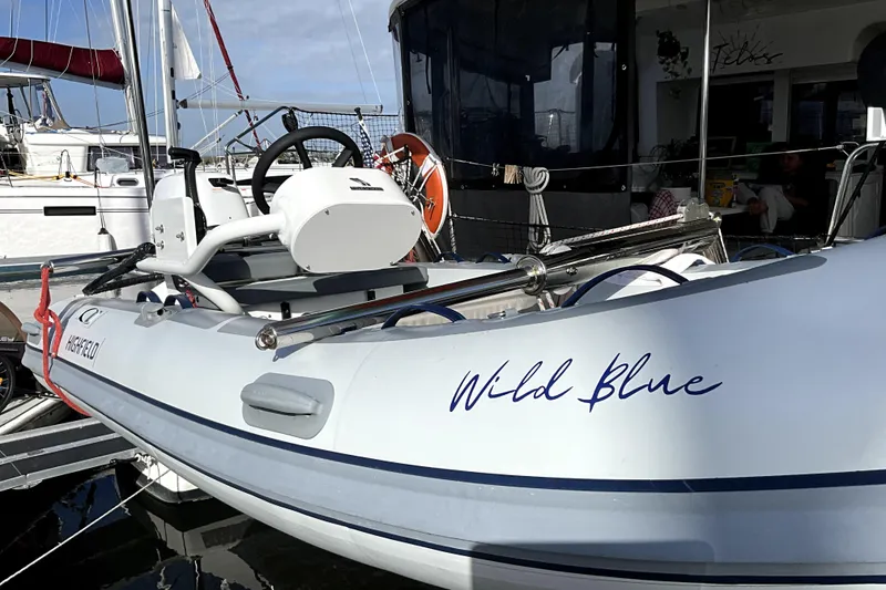 Slide: The Image of Inflatable boat "Wild Blue" docked beside Lagoon 450 F catamaran, 2016 model. - 7