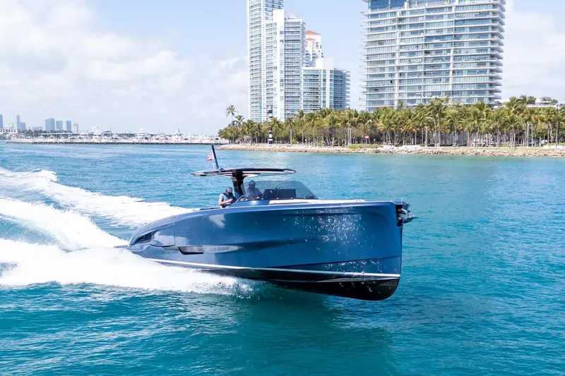 Slide: The Image of 2023 Solaris Power 44 Open yacht cruising near city skyline and palm trees. - 31