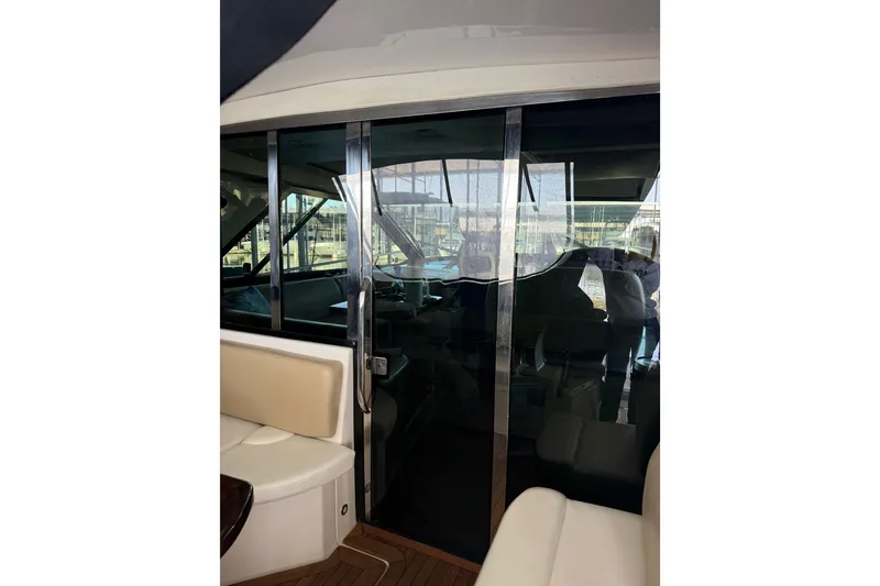 Slide: The Image of 2012 Regal 46 Sport Coupe interior with sliding glass doors and seating area. - 15