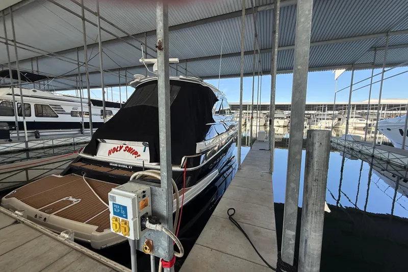 Slide: The Image of 2012 Regal 46 Sport Coupe docked in a marina under a covered shelter. - 2