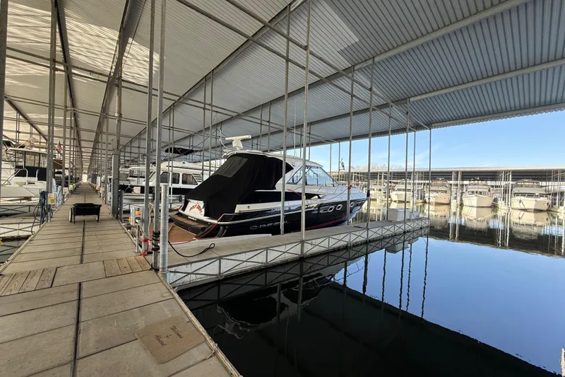 Slide: The Image of 2012 Regal 46 Sport Coupe docked in a covered marina with calm waters. - 22