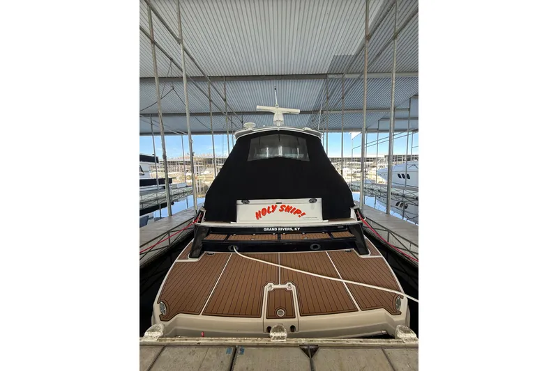 Slide: The Image of 2012 Regal 46 Sport Coupe docked, rear view with "Holy Ship!" name visible. - 3