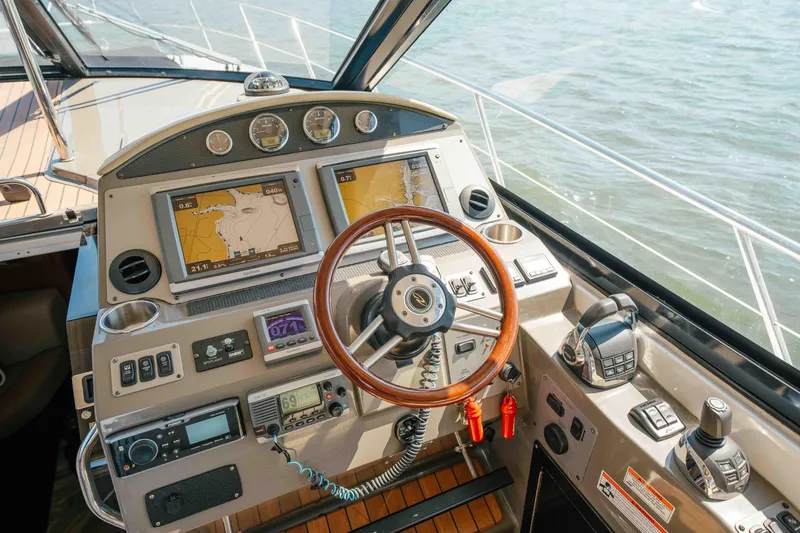 Slide: The Image of 2012 Regal 46 Sport Coupe helm with navigation screens and controls on open water. - 34
