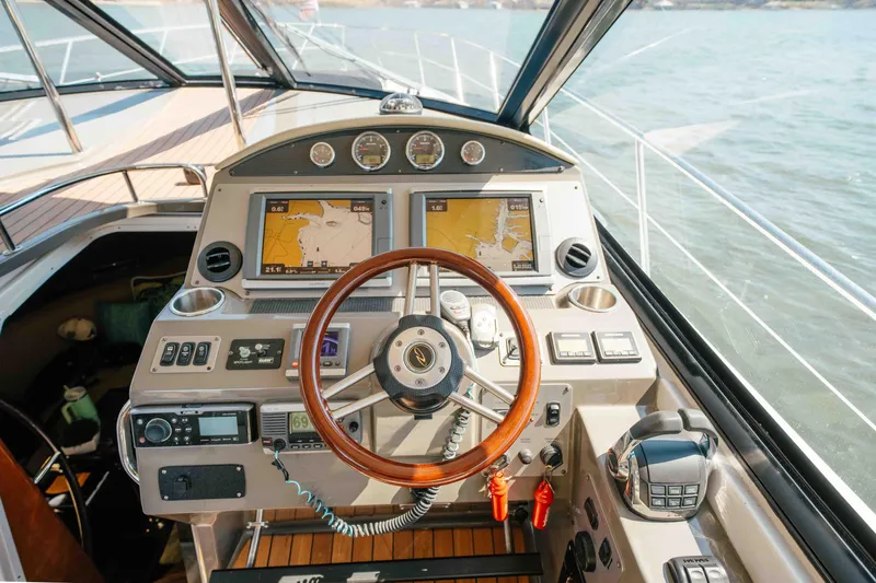 Slide: The Image of Cockpit of 2012 Regal 46 Sport Coupe with navigation screens and wooden steering wheel. - 35