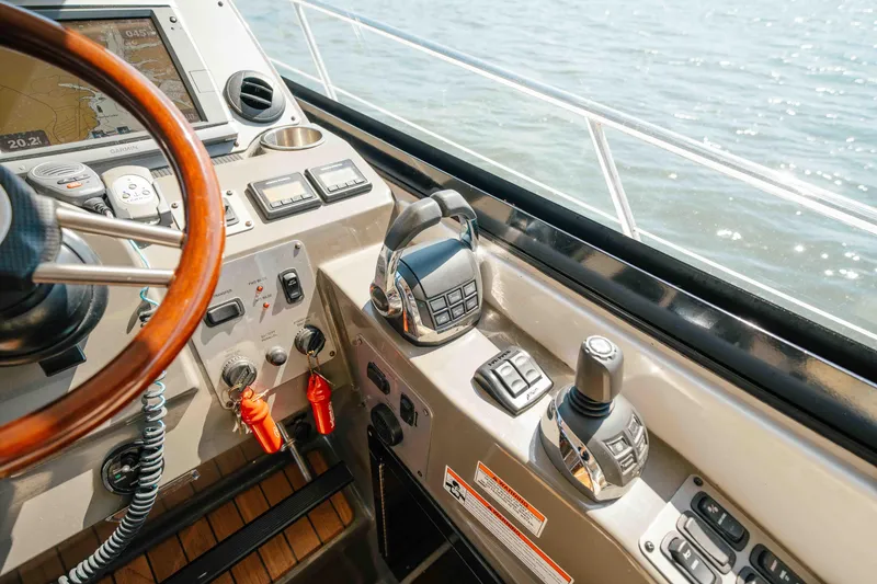 Slide: The Image of Helm of 2012 Regal 46 Sport Coupe with steering wheel and controls, overlooking water. - 39