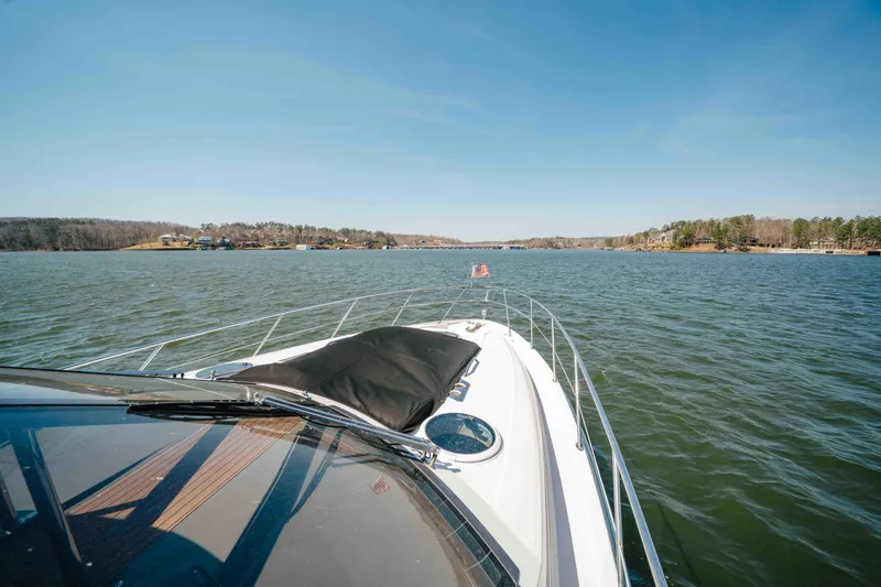 Slide: The Image of 2012 Regal 46 Sport Coupe cruising on a serene lake under clear blue skies. - 43