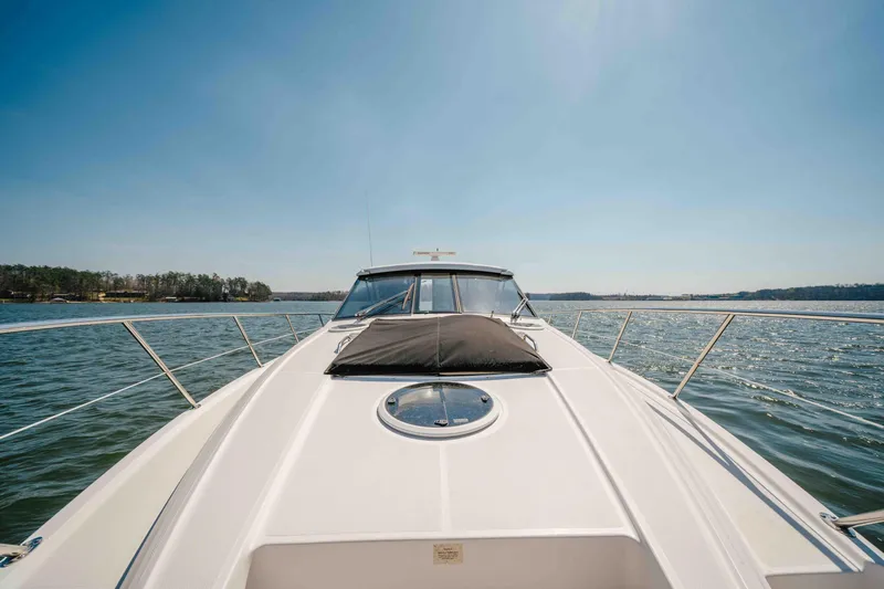 Slide: The Image of 2012 Regal 46 Sport Coupe yacht cruising on a sunny day, surrounded by calm waters. - 46