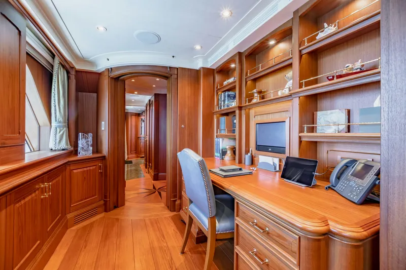 Slide: The Image of Luxurious yacht office with wooden decor, desk, and shelves, featuring modern amenities. - 13