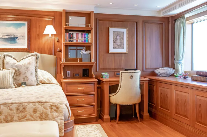 Slide: The Image of Luxurious yacht bedroom with wooden decor, cozy bed, and elegant desk area. - 16
