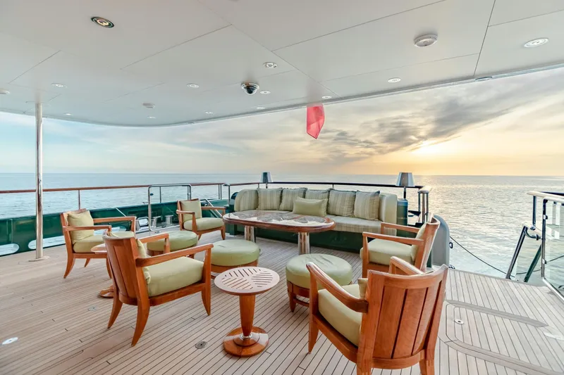 Slide: The Image of Luxurious yacht deck with elegant seating, ocean view, and sunset ambiance. Burger Custom 2010 model. - 2