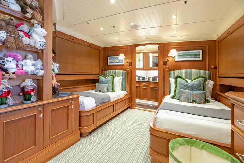 Slide: The Image of Luxurious yacht bedroom with twin beds, wooden decor, and plush toys on shelves. - 25