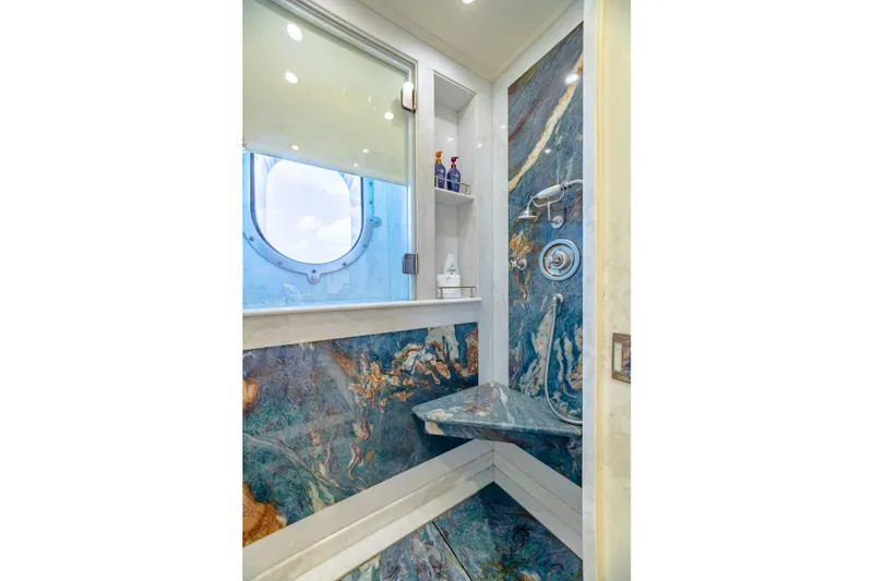 Slide: The Image of Luxurious yacht shower with marble design, porthole window, and modern fixtures. - 28