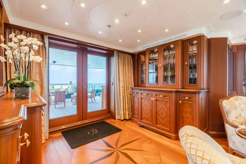 Slide: The Image of Luxurious yacht interior with elegant wood cabinetry and glass doors, featuring a scenic ocean view. - 3