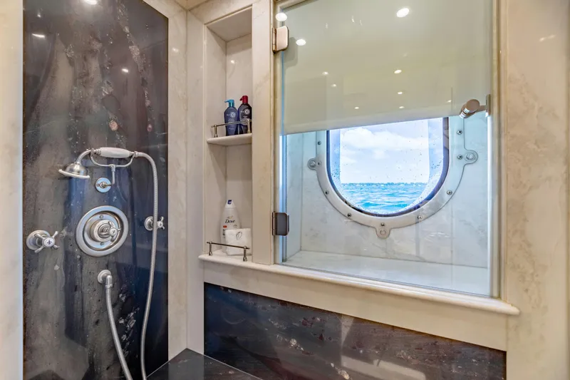Slide: The Image of Luxurious yacht shower with ocean view through porthole, featuring modern fixtures and toiletries. - 33