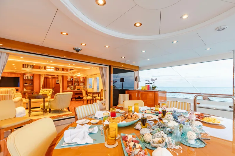 Slide: The Image of Luxurious yacht dining area with elegant table setting, ocean view, and cozy interior. Burger Custom 2010. - 45