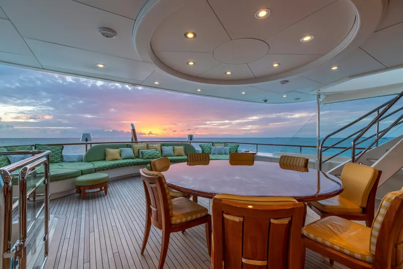 Slide: The Image of Luxurious yacht deck with sunset view, featuring elegant seating and dining area. - 47
