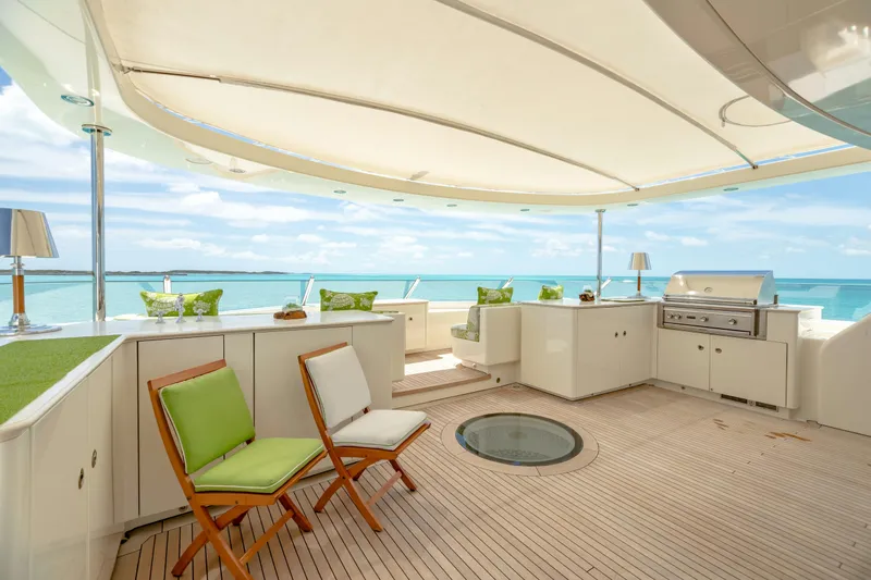 Slide: The Image of Luxurious yacht deck with seating, grill, and ocean view under a canopy. Burger Custom 2010. - 54
