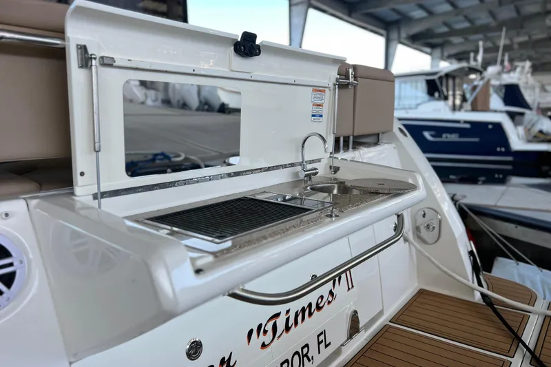 Slide: The Image of 2017 Sea Ray Sundancer 400 yacht with outdoor kitchenette and sink in marina setting. - 12