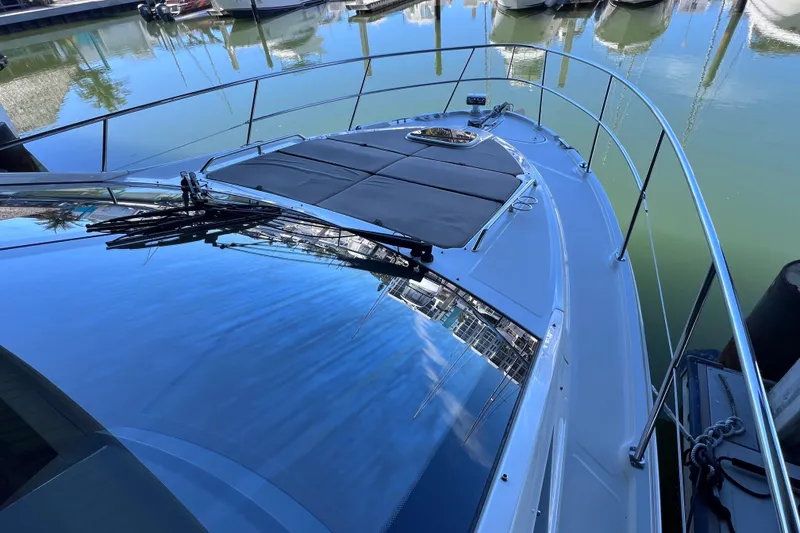 Slide: The Image of 2017 Sea Ray Sundancer 400 yacht docked, reflecting clear blue sky on water. - 25