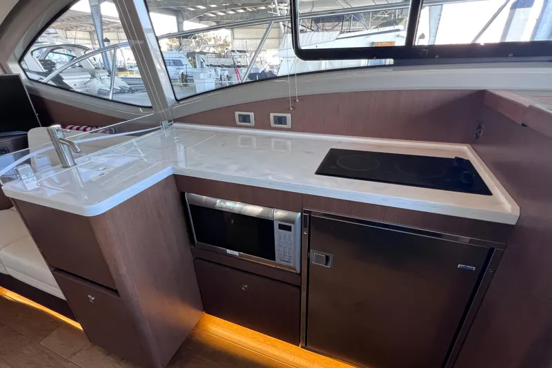 Slide: The Image of Modern kitchen area in 2017 Sea Ray Sundancer 400 yacht with stove, microwave, and fridge. - 46