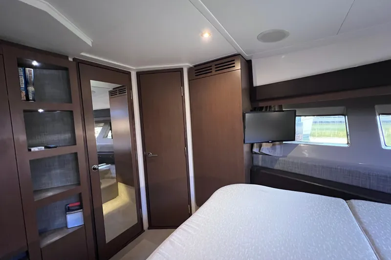 Slide: The Image of Luxurious 2017 Sea Ray Sundancer 400 cabin with modern wood finishes and a mounted TV. - 70