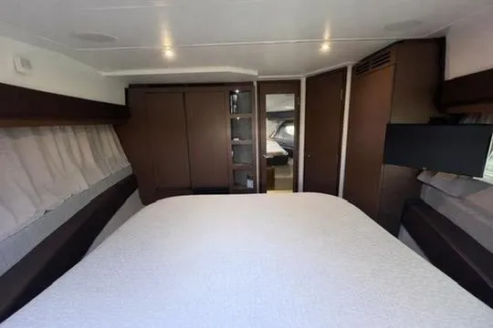 Slide: The Image of Luxurious 2017 Sea Ray Sundancer 400 cabin interior with modern furnishings and cozy bedding. - 74