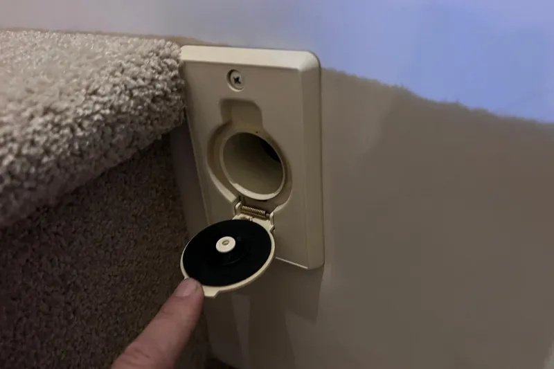 Slide: The Image of Wall-mounted outlet on 2017 Sea Ray Sundancer 400 yacht, with open cover and carpeted surroundings. - 86