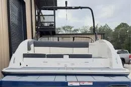 Slide: The Image of 2022 Bayliner DX 2250 boat, rear view, docked near industrial building. - 10