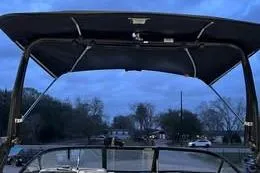Slide: The Image of Bayliner DX 2250 boat, 2022 model, with a canopy against a twilight sky. - 3