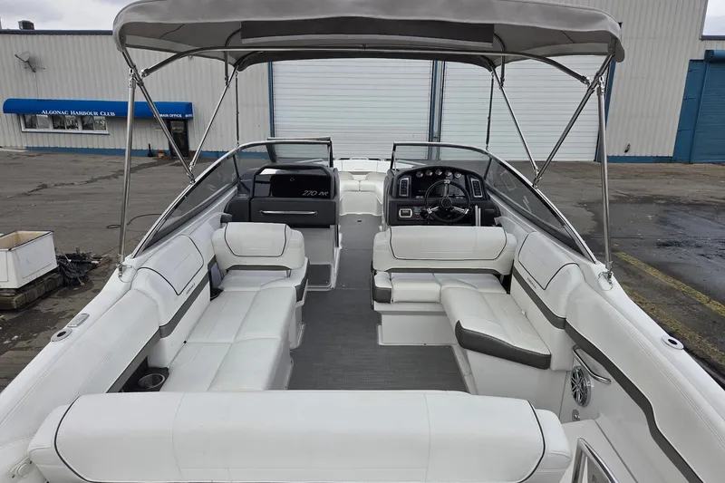 Slide: The Image of 2022 Formula 270 Bowrider boat interior with white seating and canopy at dock. - 19