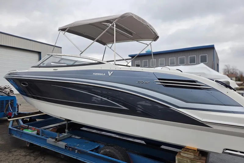 Slide: The Image of 2022 Formula 270 Bowrider boat with canopy, displayed on a trailer in a marina setting. - 9