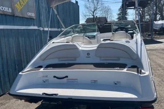 Slide: The Image of 2012 Yamaha Boats SX190, white, rear view, parked outdoors near blue fence. - 3