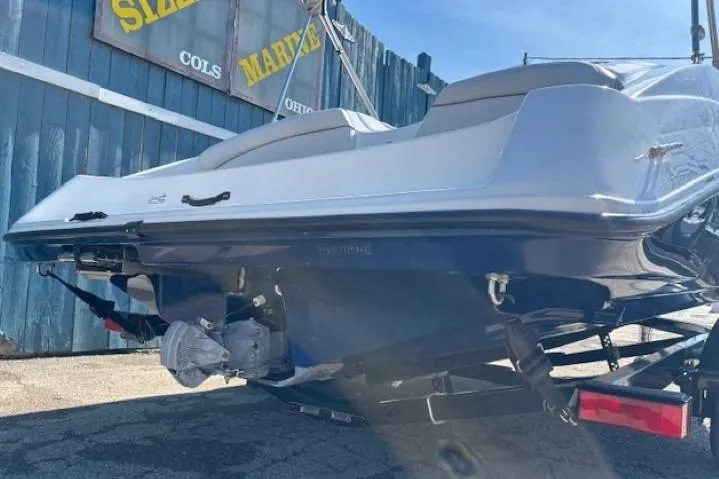 Slide: The Image of 2012 Yamaha Boats SX190 on trailer, rear view, parked near blue wooden fence. - 4