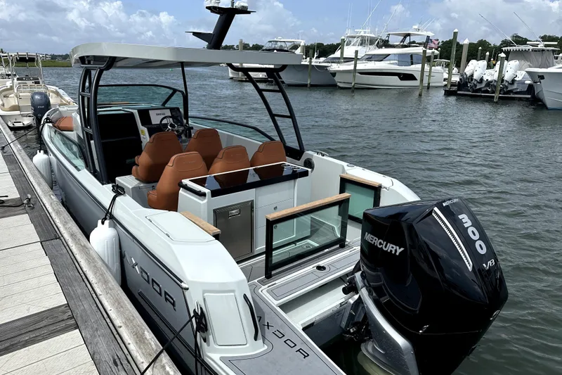 Slide: The Image of 2024 Saxdor 320 GTO boat docked, featuring Mercury 300 V8 engine. - 2