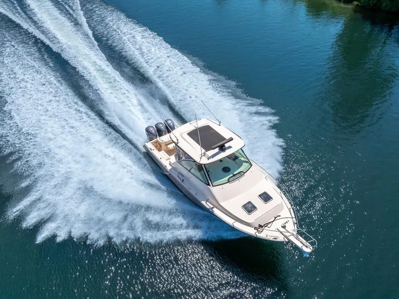 Slide: The Image of 2019 Grady-White Express boat cruising on clear blue water, leaving a wake. - 11