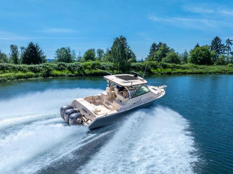 Slide: The Image of 2019 Grady-White Express boat cruising on a scenic river under a clear blue sky. - 12