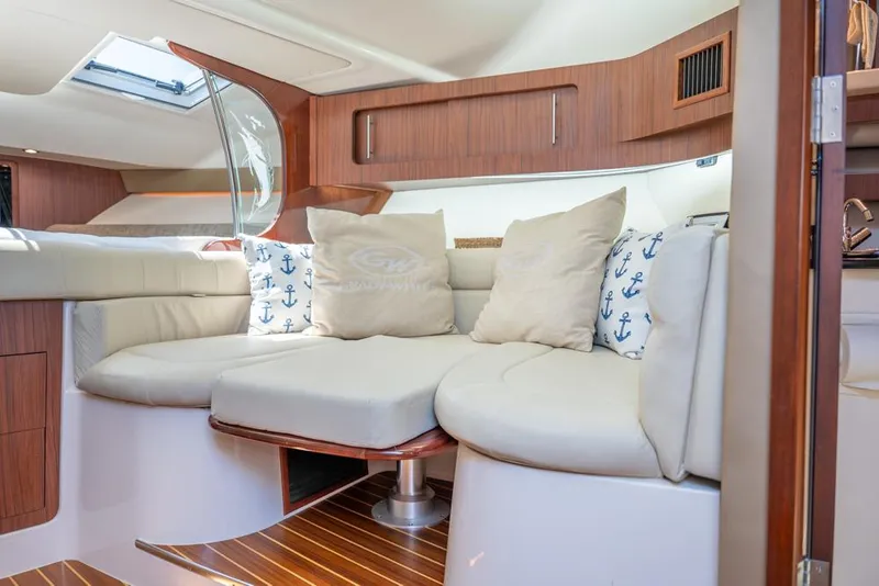 Slide: The Image of 2019 Grady-White Express boat interior with plush seating and nautical-themed cushions. - 15