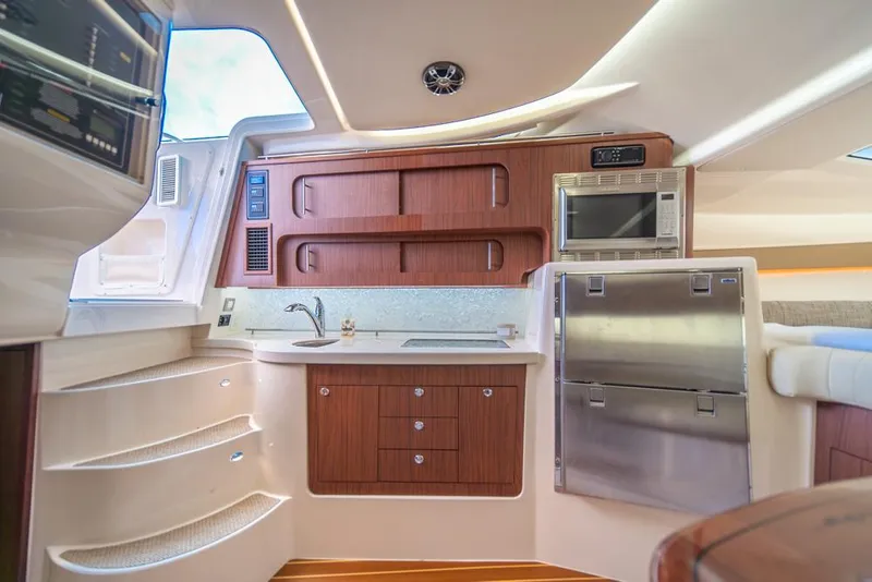 Slide: The Image of 2019 Grady-White Express boat interior with modern kitchen and wooden cabinetry. - 17