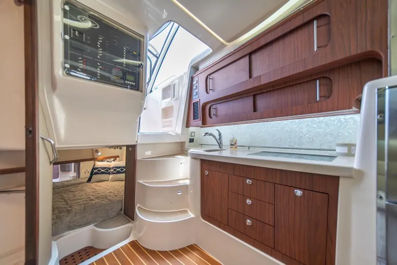 Slide: The Image of 2019 Grady-White Express boat interior with wood cabinetry and compact kitchen area. - 21