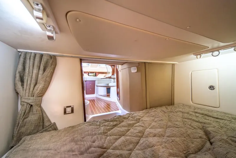 Slide: The Image of 2019 Grady-White Express cabin interior with bed, curtain, and wooden flooring. - 23