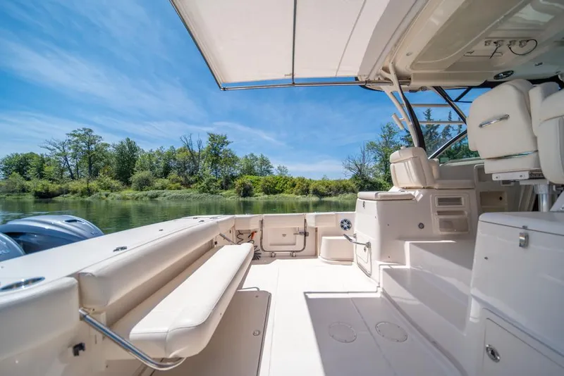 Slide: The Image of 2019 Grady-White Express boat interior with seating, under a clear blue sky. - 31