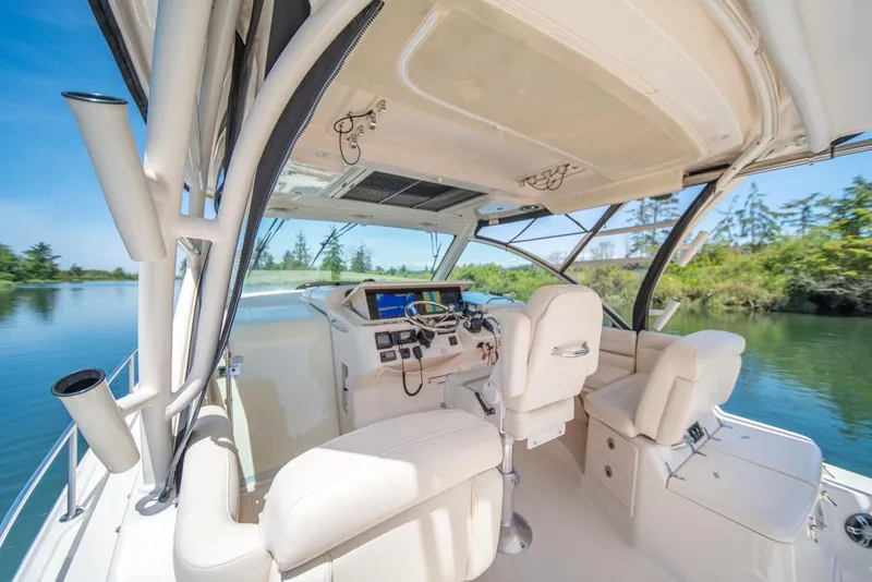 Slide: The Image of 2019 Grady-White Express boat interior with helm, white seating, and scenic water view. - 35