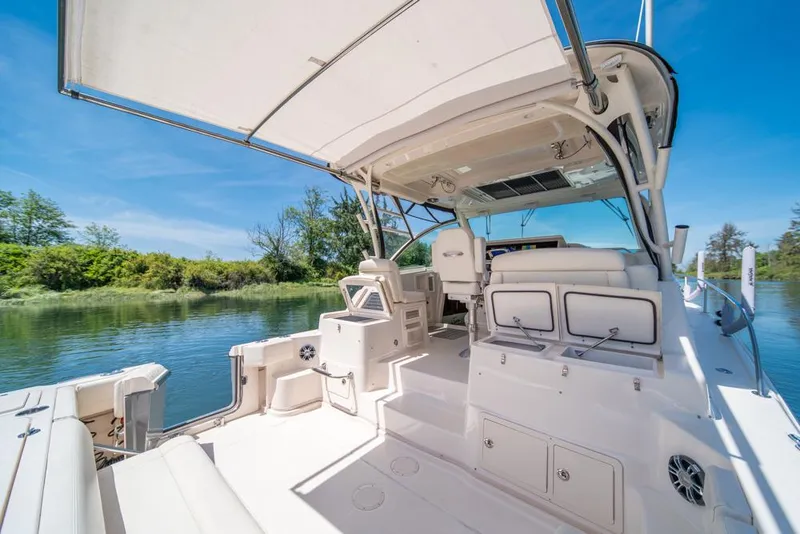 Slide: The Image of 2019 Grady-White Express boat interior with seating, canopy, and scenic water view. - 45