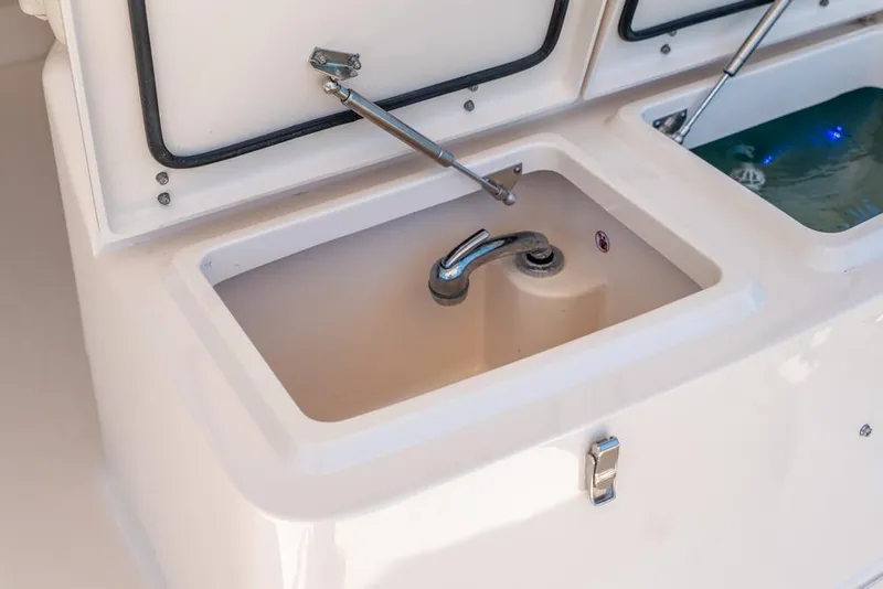 Slide: The Image of 2019 Grady-White Express boat sink and storage compartments. - 49