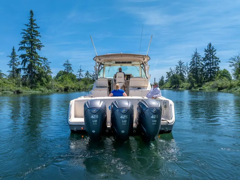 Slide: The Image of 2019 Grady-White Express boat cruising on a serene lake with lush greenery. - 5