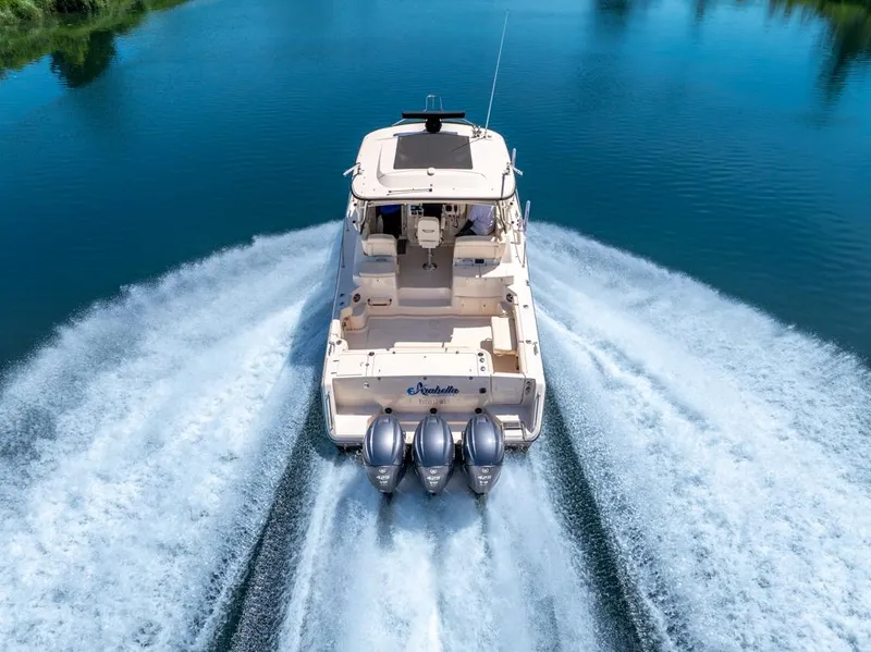 Slide: The Image of 2019 Grady-White Express boat cruising on a serene blue lake. - 7