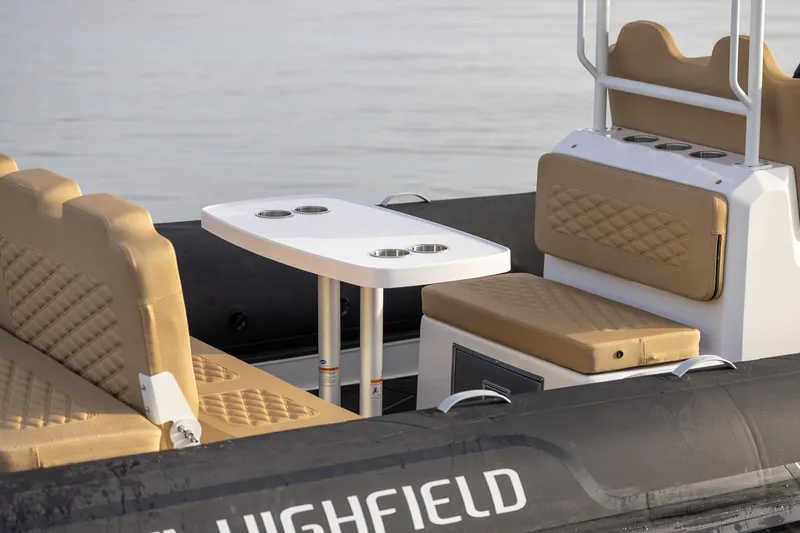 Slide: The Image of 2026 Highfield Sport 800 boat interior with tan seating and white table. - 10