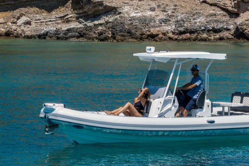 Slide: The Image of 2026 Highfield Sport 800 boat cruising on clear blue water near rocky shoreline. - 7