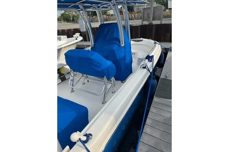 Slide: The Image of 2018 Robalo R222 Explorer boat with blue covers docked at a marina. - 11