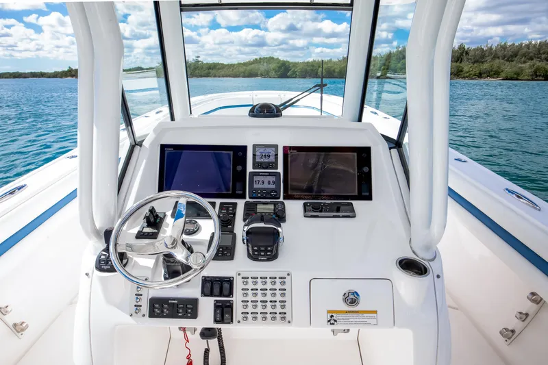 Slide: The Image of 2017 Intrepid 375 Center Console boat dashboard with navigation screens and steering wheel. - 10
